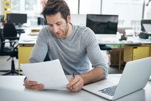 hombre con laptop y documento