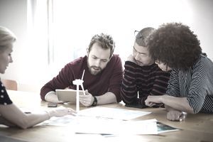 Profesionalų grupė, dirbanti kartu, kad išspręstų vėjo turbinos projektavimo problemą.
